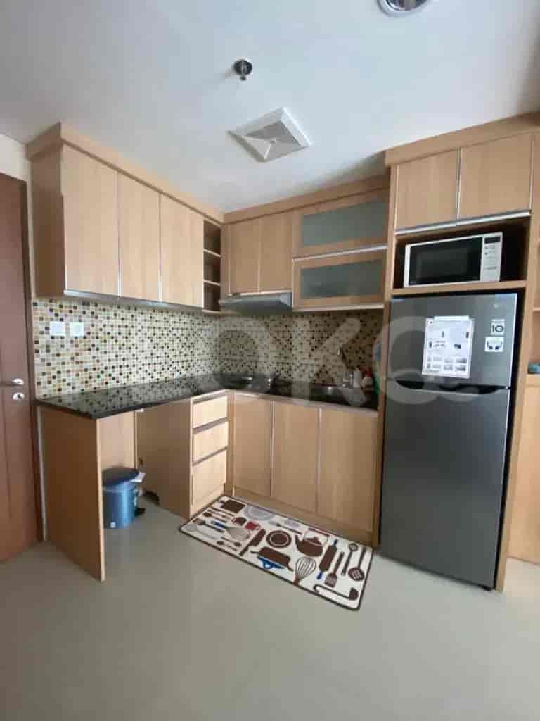 A well-organized kitchenette featuring wooden cabinets, a refrigerator, and a microwave.