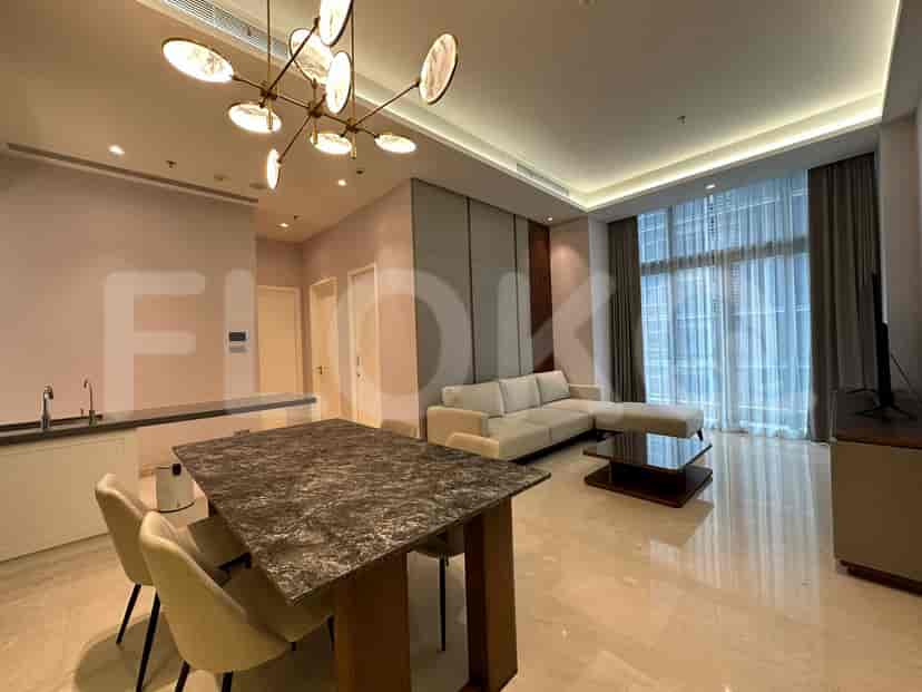 A modern living space with an L-shaped sofa, dining area, and a large window.