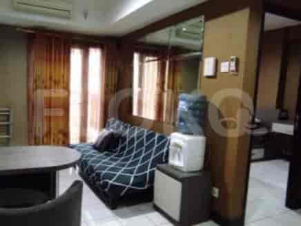 Cozy living space with a sofa, table, and water dispenser.