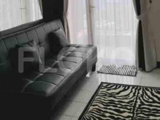 A black leather sofa in front of a balcony.