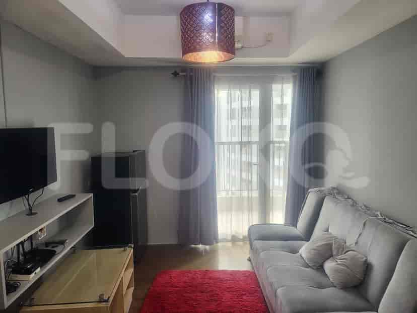 Living room with a grey sofa, a smart TV, and a red carpet.