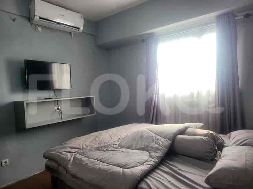 Bedroom with a bed, a TV, and curtains.