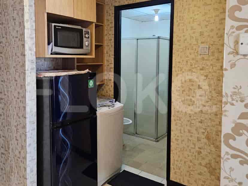 Kitchen with a refrigerator, microwave, and access to a bathroom.