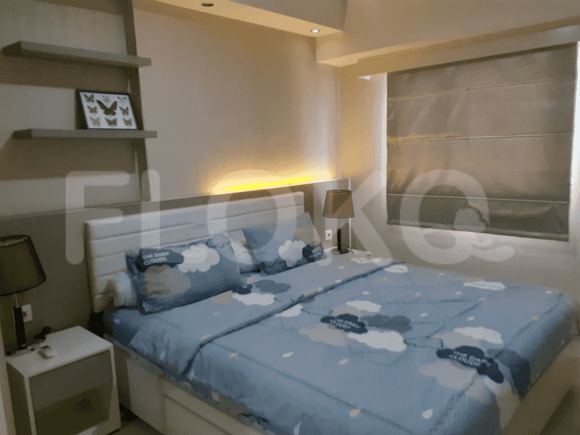Well-lit bedroom with a bed, nightstands, and decor.