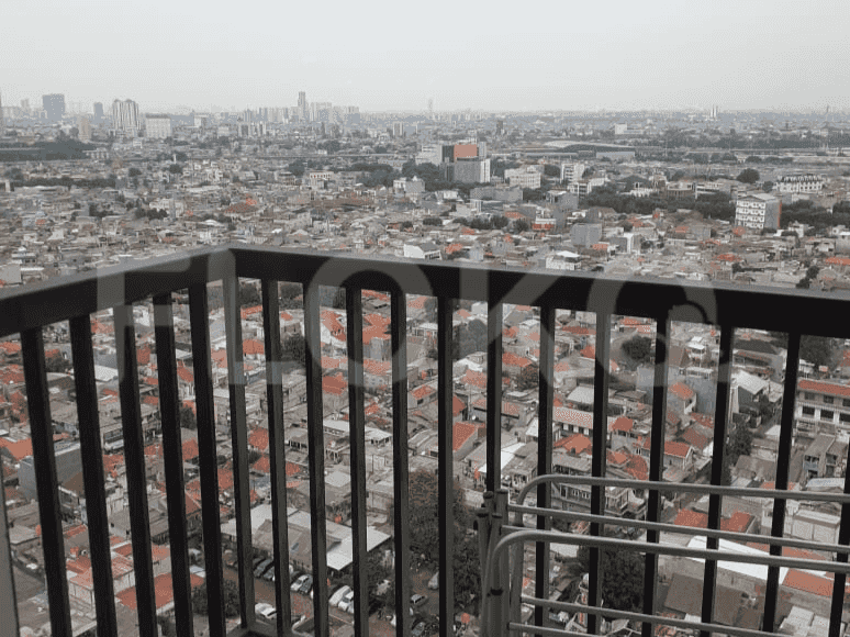 Balcony with a metal railing offering a city view.