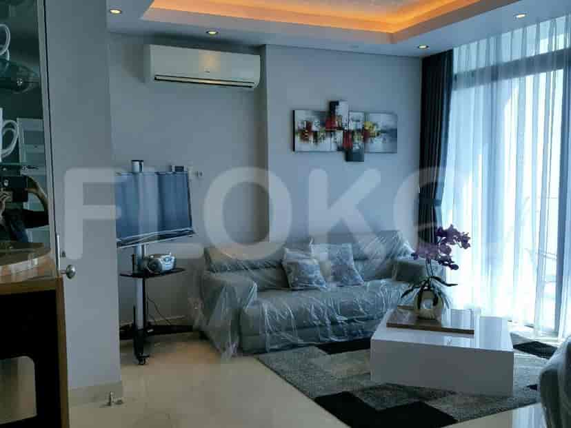 Pemandangan ruang tamu dengan sofa dan TV pintar.