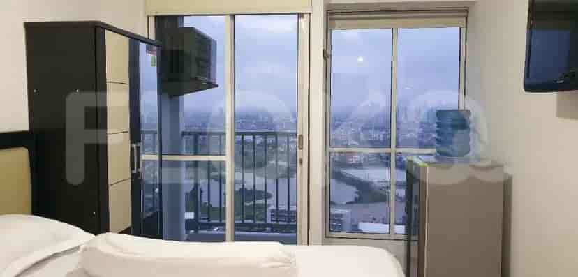 A studio apartment bedroom with a bed, wardrobe, and city view.