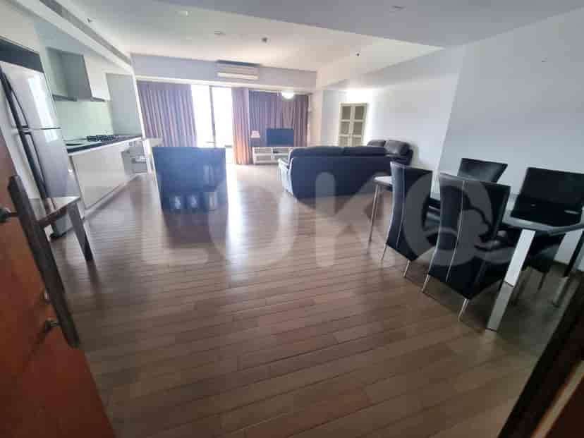 View from the entrance, showing the living room, dining area, and kitchen with a refrigerator.