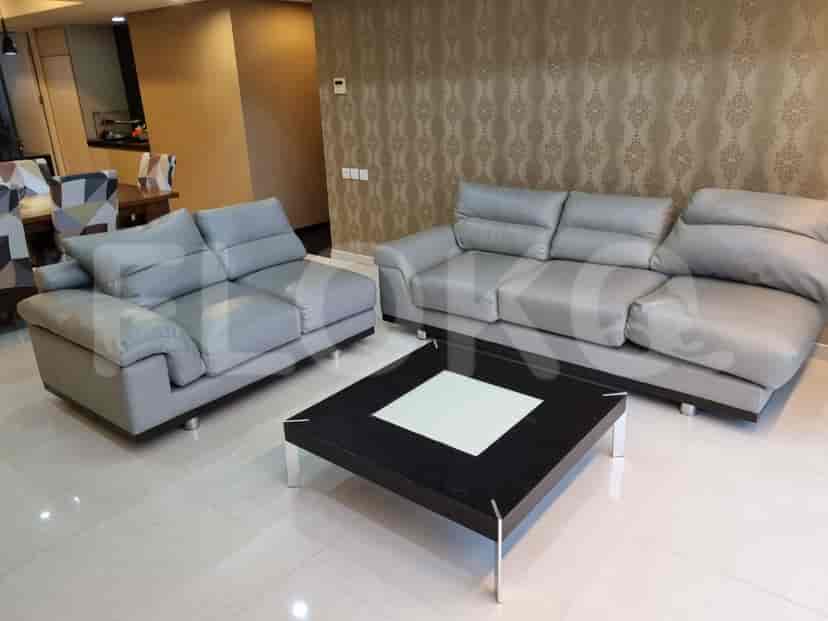 Ruang tamu yang menampilkan sofa kulit abu-abu dan meja kopi hitam.