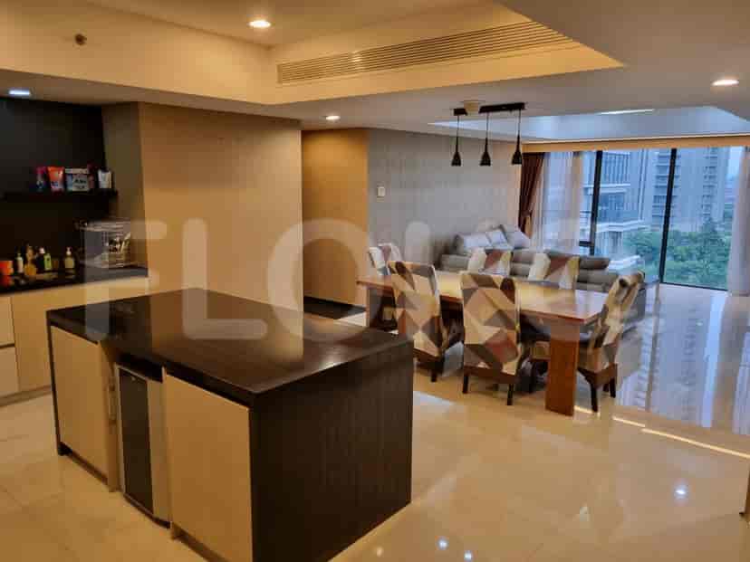 Area terbuka ruang tamu dan makan dengan pulau dapur, dan meja makan dengan kursi.