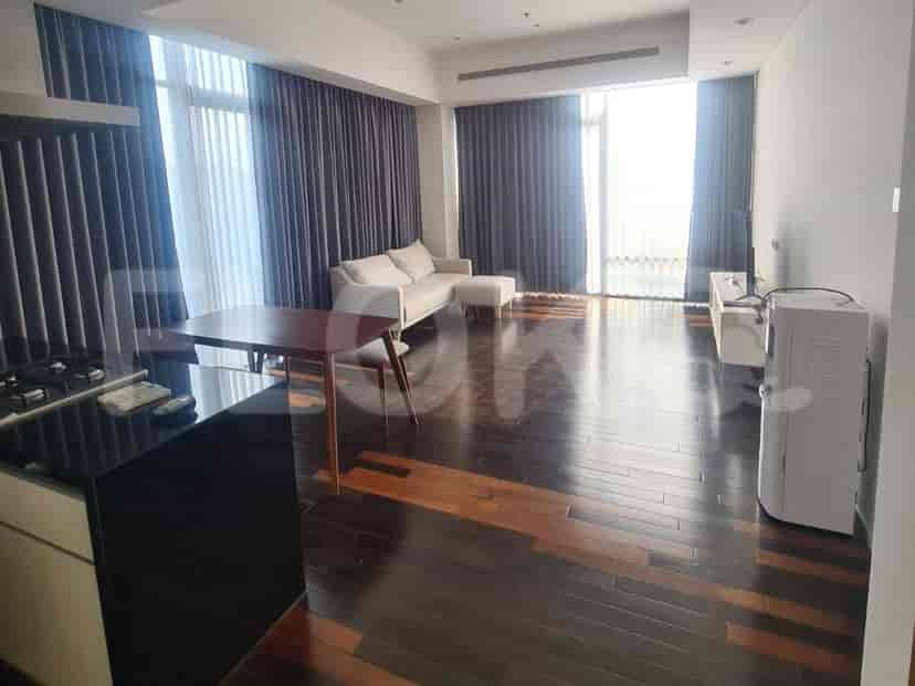Modern living room with a sofa, dining table, and floor-to-ceiling windows.