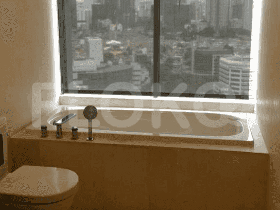Kamar mandi dengan bathtub menghadap kota.