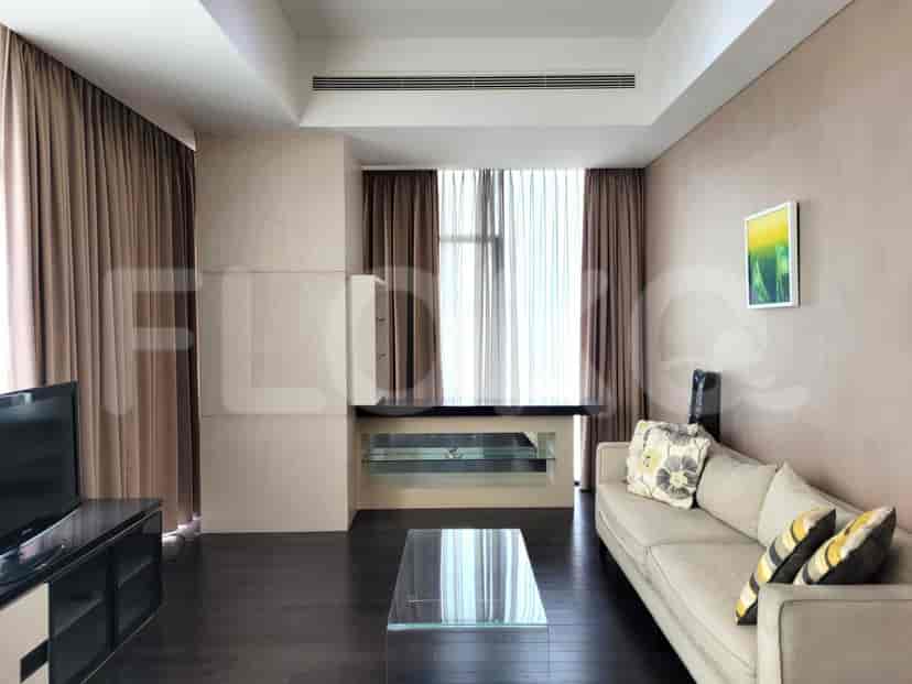 Spacious living room with dark wood flooring, a large window, and neutral tones.