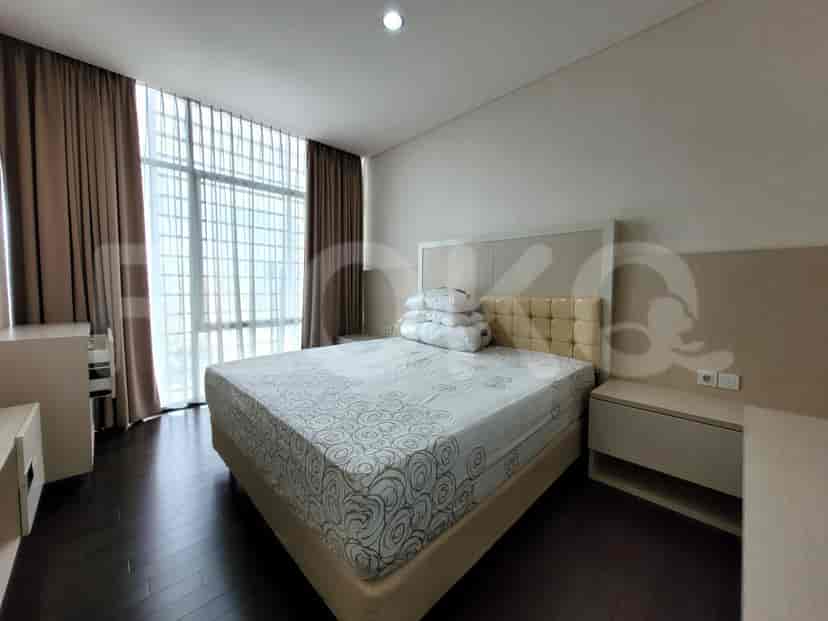 Comfortable bedroom with a double bed, wooden flooring, and light-colored walls.