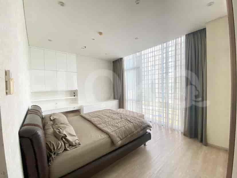 A bedroom with a bed, desk, and a view.