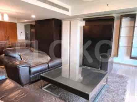 Living room with a leather sofa, glass table, and built-in storage.