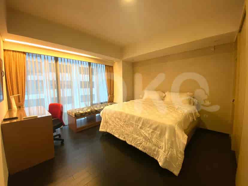 Bedroom with a bed, large window, and a desk.