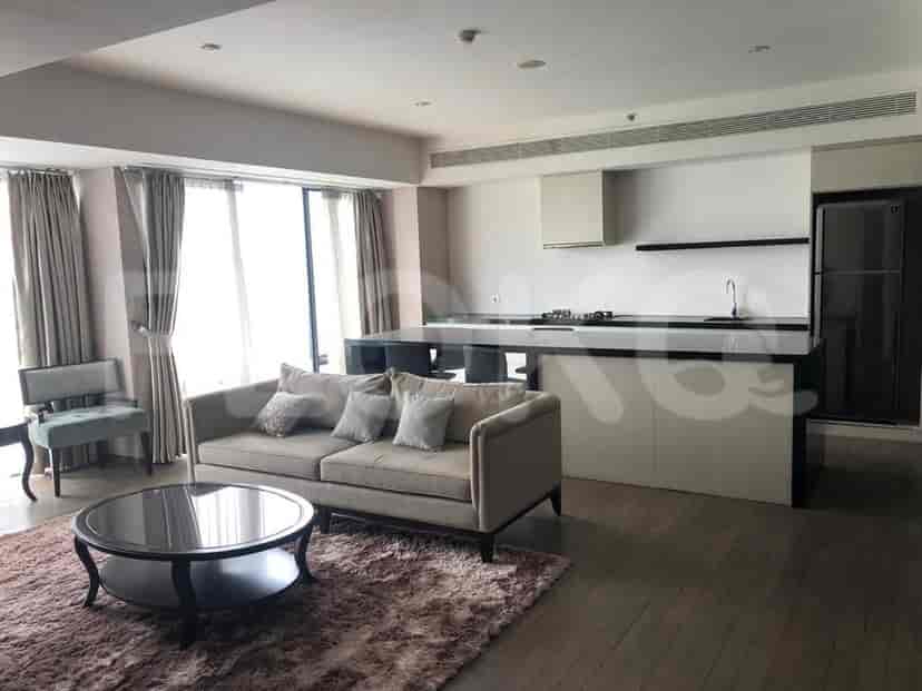 Spacious living room with a kitchen and large windows.