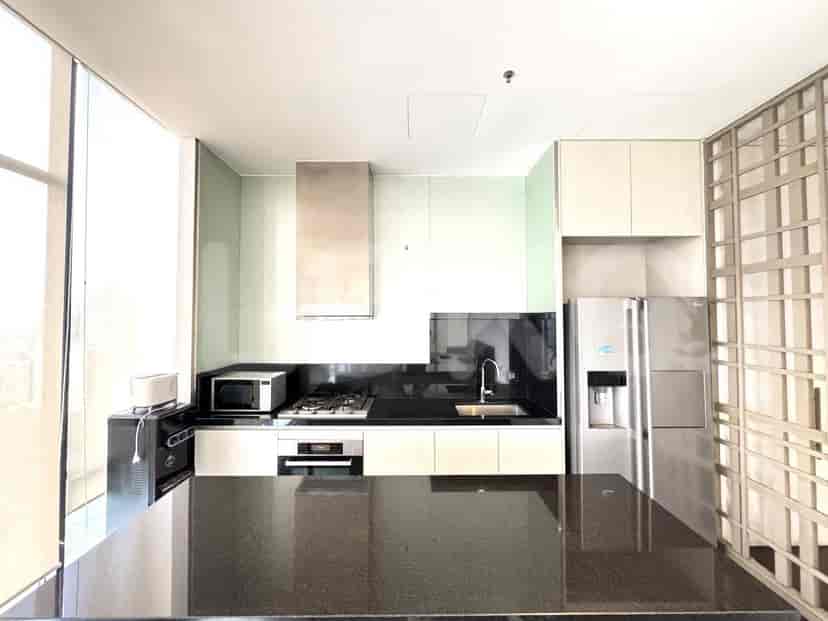 Modern kitchen with stainless steel appliances and black countertops.