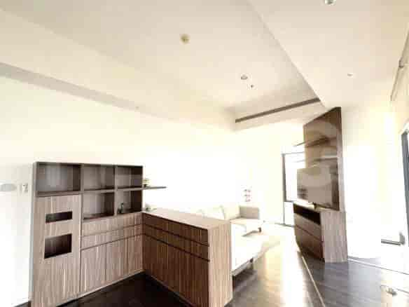 Living room with wooden cabinets and a beige sofa.