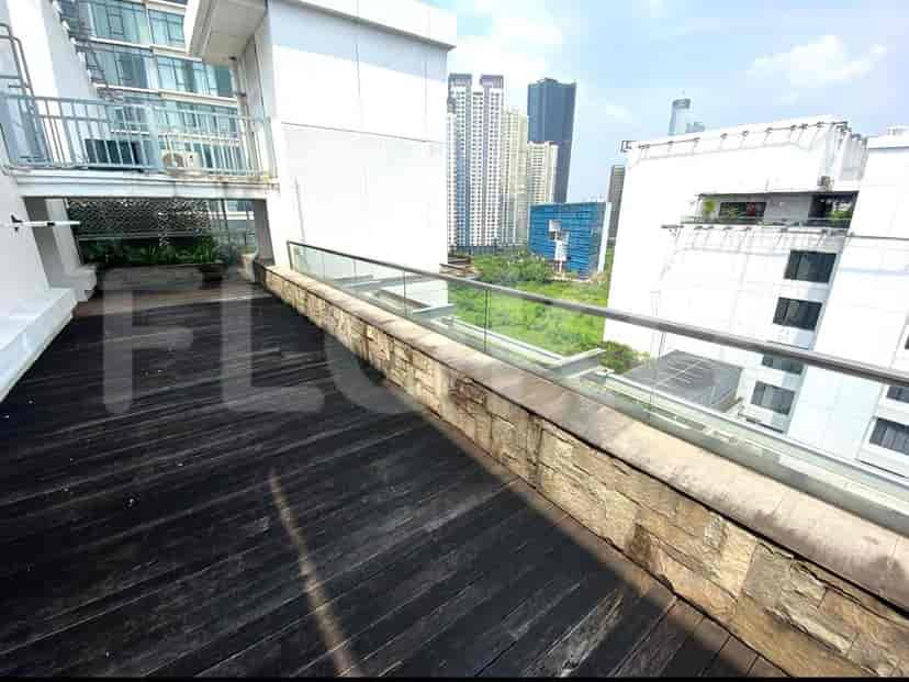 A rooftop terrace with a view of city buildings.