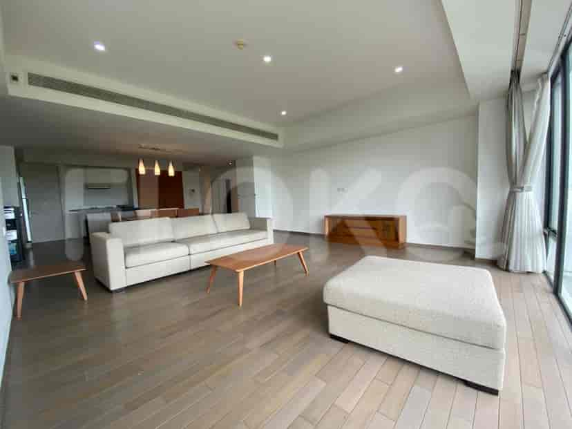 Modern living room with a grey sofa, wooden coffee table, and ottoman.