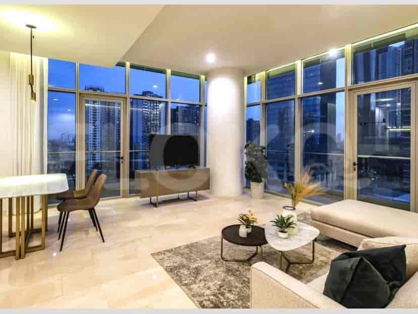 Spacious living room at night with city view, including dining table and TV unit.