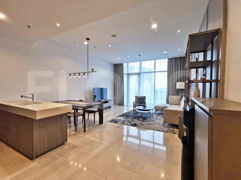 Open living area with dining, kitchen and living space, natural lighting from the large windows.