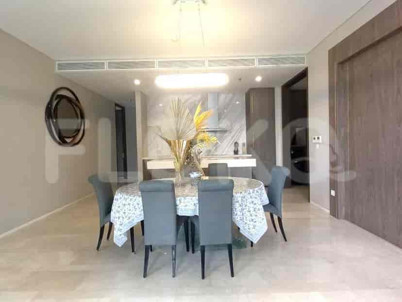 Spacious dining area with a round table, 6 chairs, and a chandelier.