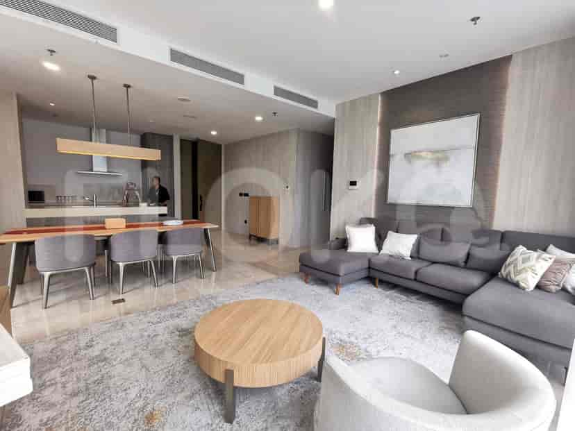 Spacious living room with dining area, grey sofa, and a modern aesthetic.