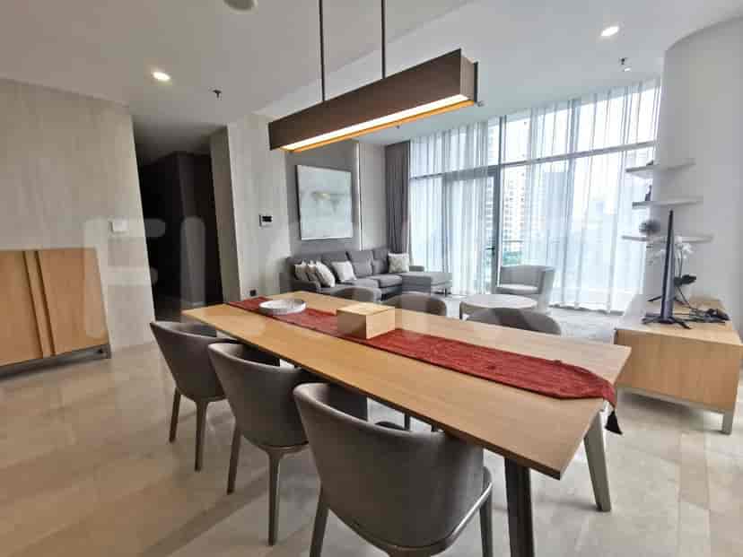 Spacious living room with dining area, featuring a grey sofa and modern design.