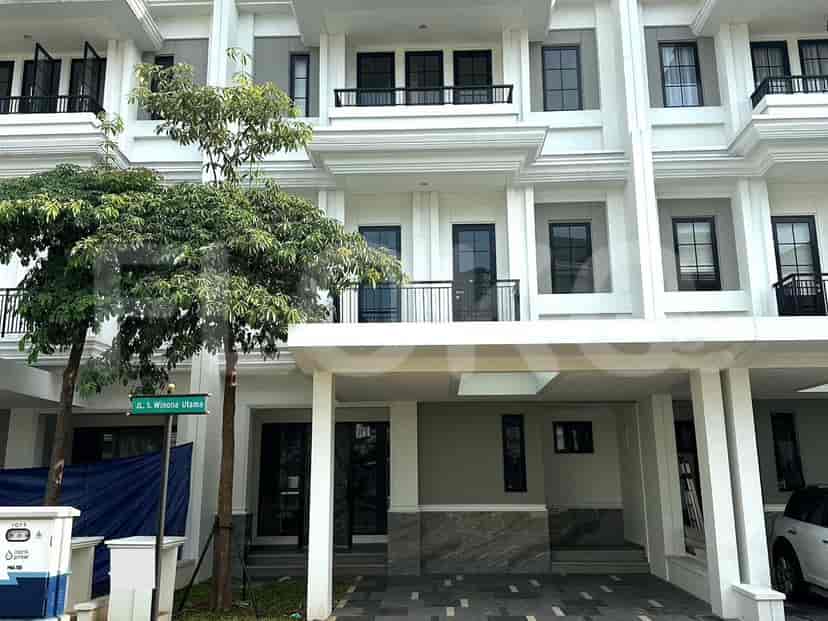 A modern multi-story townhouse with a covered carport and a street sign.