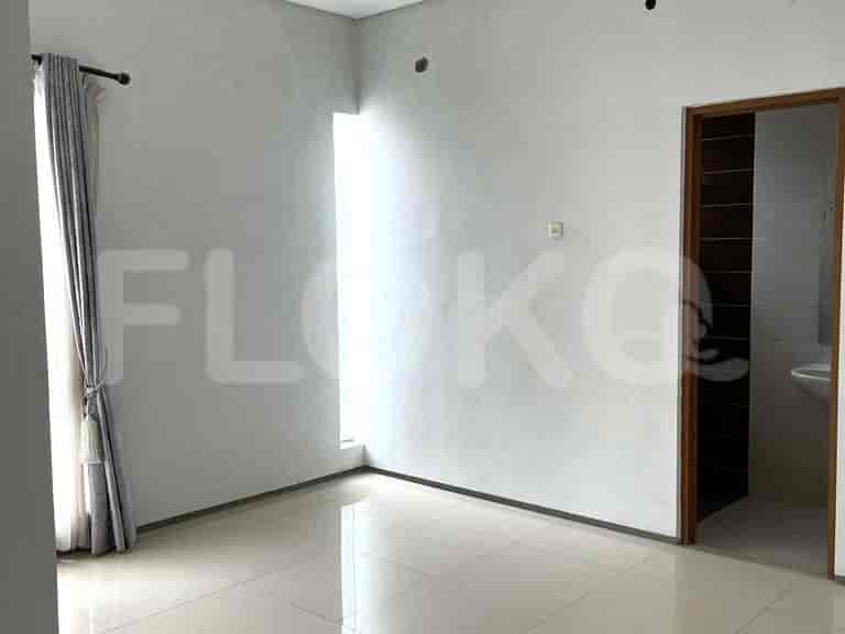 A room with tiled flooring, white walls, and a doorway to the bathroom.