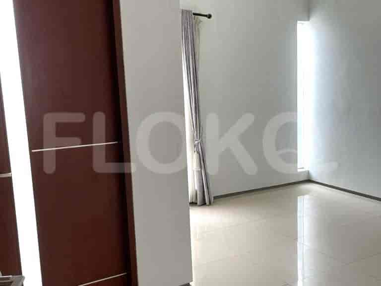 A room with tiled flooring, white walls, and a doorway to a room.