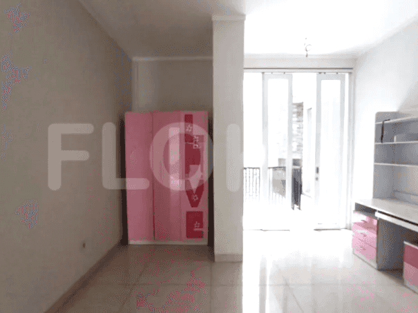 Pemandangan lain dari kamar tidur dengan lemari merah muda dan akses ke balkon.
