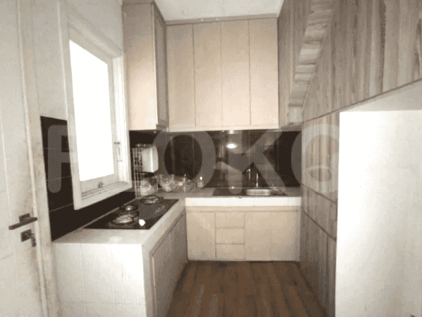Dapur ringkas dengan lemari kayu, kompor gas, dan backsplash gelap.