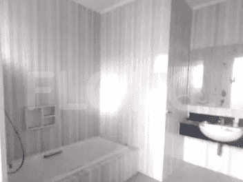 Kamar mandi dengan bak mandi, cermin rias, dan wallpaper bermotif.