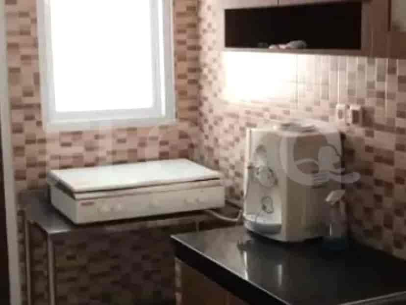 A kitchen with a stove, overhead cabinets, and countertops.