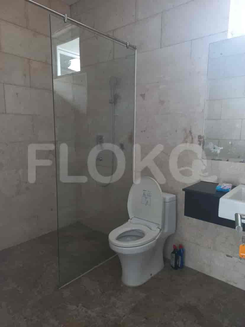 A modern bathroom with a glass-enclosed shower, a white toilet, and light-colored walls.