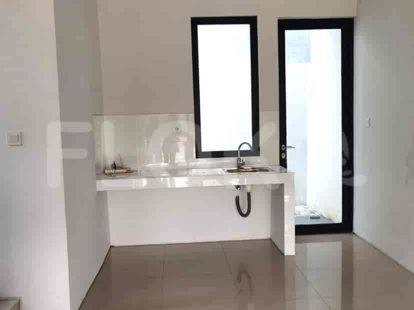 Dapur kosong dengan meja berubin, wastafel, dan pintu ke luar.
