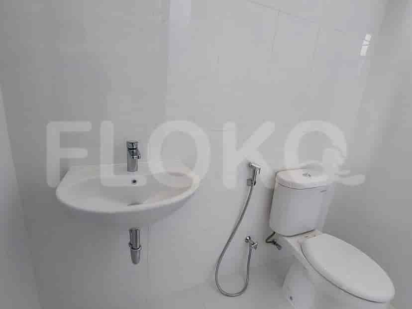 Kamar mandi dengan wastafel putih, toilet, dan semprotan bidet.