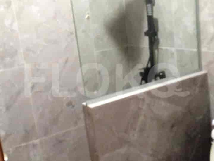Area shower dengan penutup kaca dan dinding berubin abu-abu.