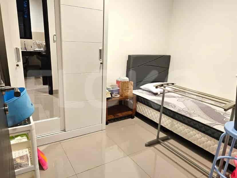 Kamar tidur dengan tempat tidur tunggal, meja samping, dan lemari pakaian pintu geser.