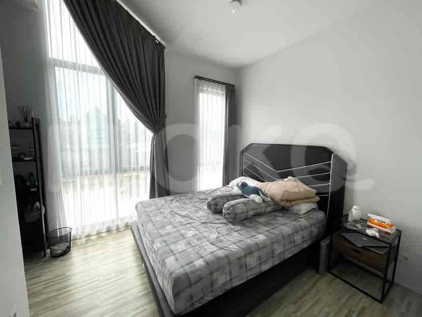Kamar tidur yang cerah dengan tempat tidur besar, sprei berwarna netral, dan gorden tipis.