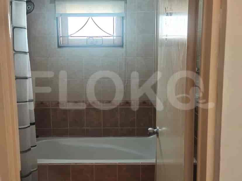 Kamar mandi dengan bak mandi built-in, tirai shower, dan dinding ubin.