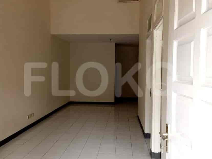 Sebuah ruang interior kosong dengan lantai berubin dan dinding berwarna krem.