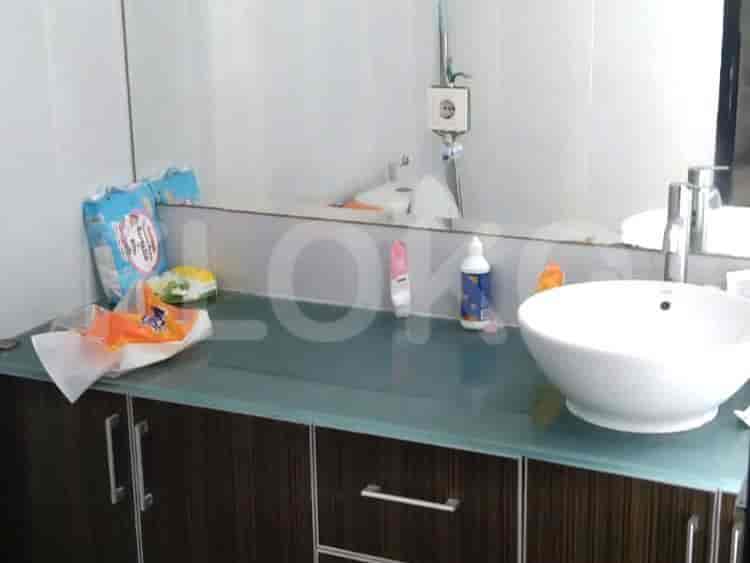 Vanity kamar mandi dengan wastafel, cermin, dan perlengkapan mandi.