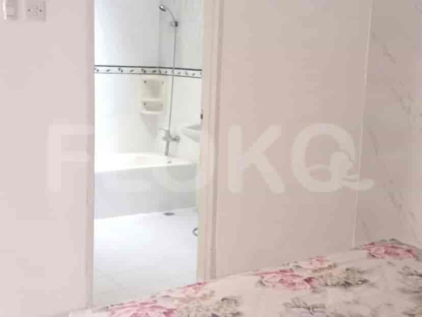 A bathroom with a bathtub, toilet, and shower head.