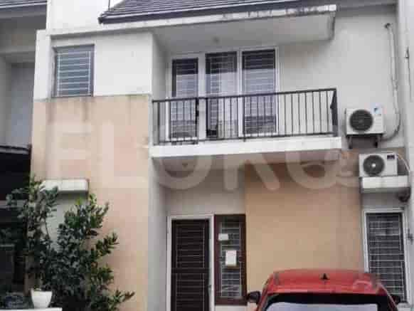 A two-story house with a balcony, air conditioning units, and a red car parked in front.