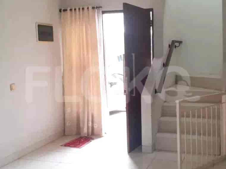 An entryway with a staircase leading up, a curtained doorway, and a tiled floor.